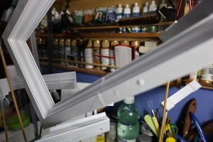 Proceso de construcción del diorama "Las Gemelas": recreación artesanal del pasillo del hotel Overlook con papel pintado geométrico en miniatura, carpintería detallada de puertas de hotel