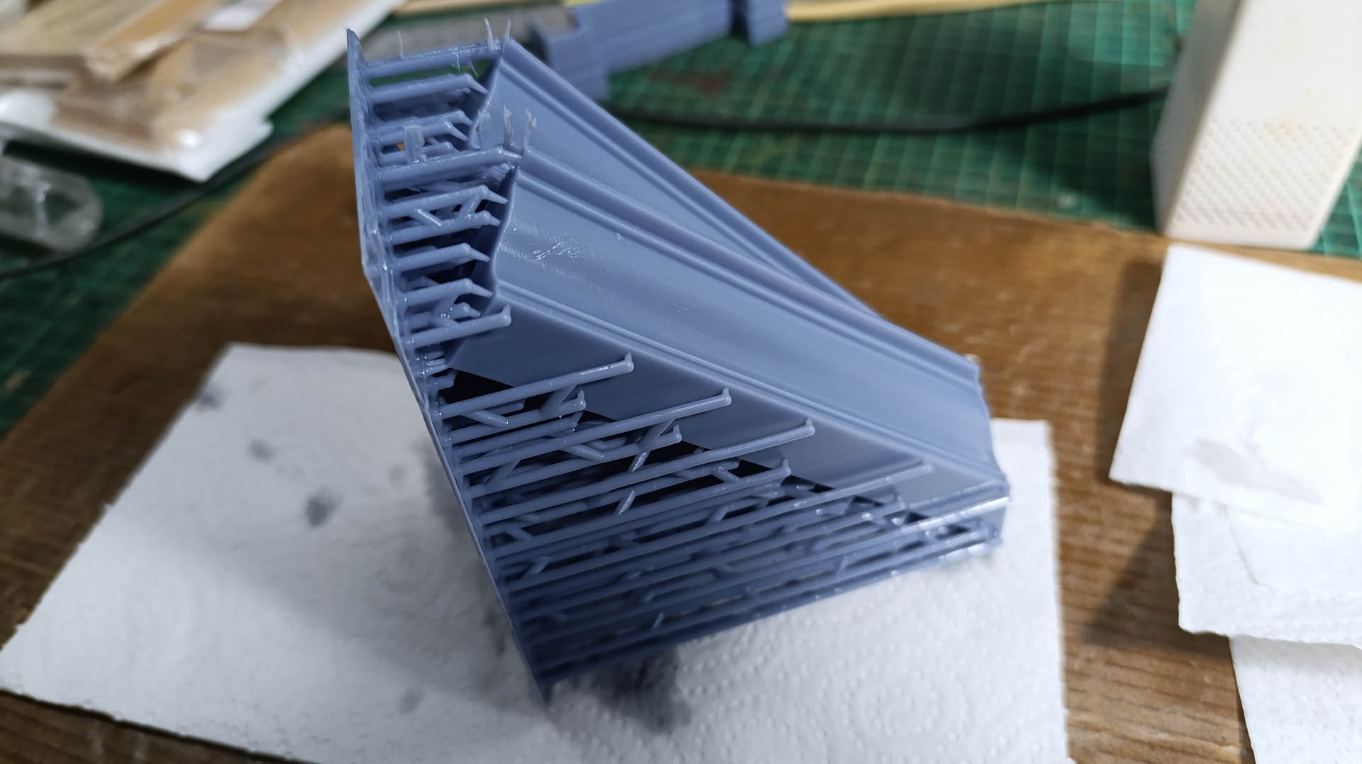 Proceso de construcción del diorama "Las Gemelas": recreación artesanal del pasillo del hotel Overlook con papel pintado geométrico en miniatura, carpintería detallada de puertas de hotel