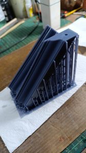 Proceso de construcción del diorama "Las Gemelas": recreación artesanal del pasillo del hotel Overlook con papel pintado geométrico en miniatura, carpintería detallada de puertas de hotel