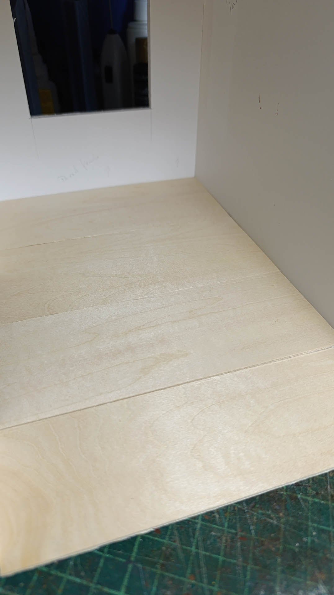 Proceso de construcción del diorama "Las Gemelas": recreación artesanal del pasillo del hotel Overlook con papel pintado geométrico en miniatura, carpintería detallada de puertas de hotel