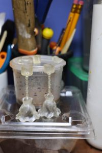 Proceso de construcción del diorama "Las Gemelas": recreación artesanal del pasillo del hotel Overlook con papel pintado geométrico en miniatura, carpintería detallada de puertas de hotel