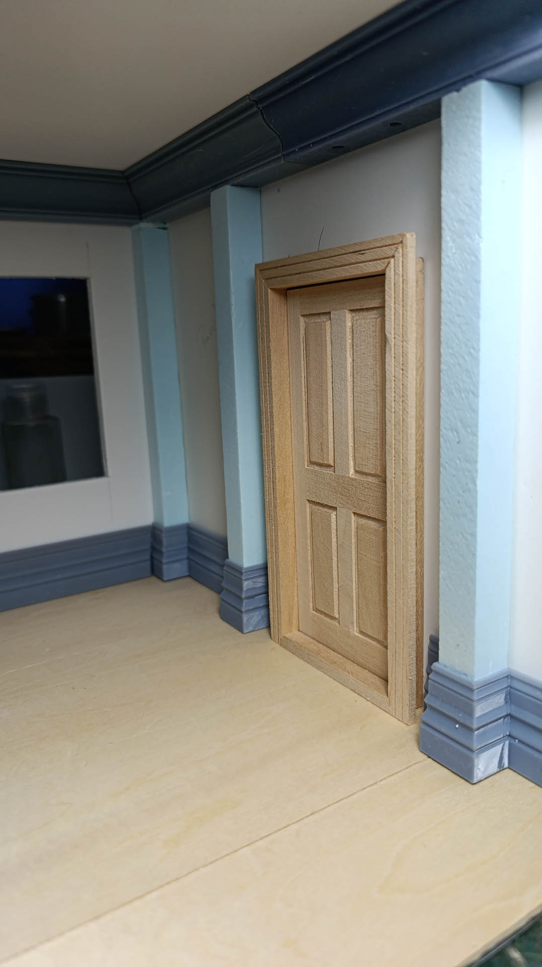 Proceso de construcción del diorama "Las Gemelas": recreación artesanal del pasillo del hotel Overlook con papel pintado geométrico en miniatura, carpintería detallada de puertas de hotel