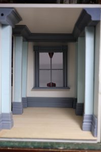 Proceso de construcción del diorama "Las Gemelas": recreación artesanal del pasillo del hotel Overlook con papel pintado geométrico en miniatura, carpintería detallada de puertas de hotel