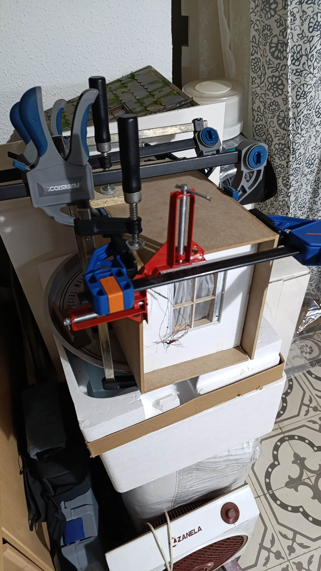 Proceso de construcción del diorama "Las Gemelas": recreación artesanal del pasillo del hotel Overlook con papel pintado geométrico en miniatura, carpintería detallada de puertas de hotel