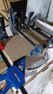 Proceso de construcción del diorama "Las Gemelas": recreación artesanal del pasillo del hotel Overlook con papel pintado geométrico en miniatura, carpintería detallada de puertas de hotel