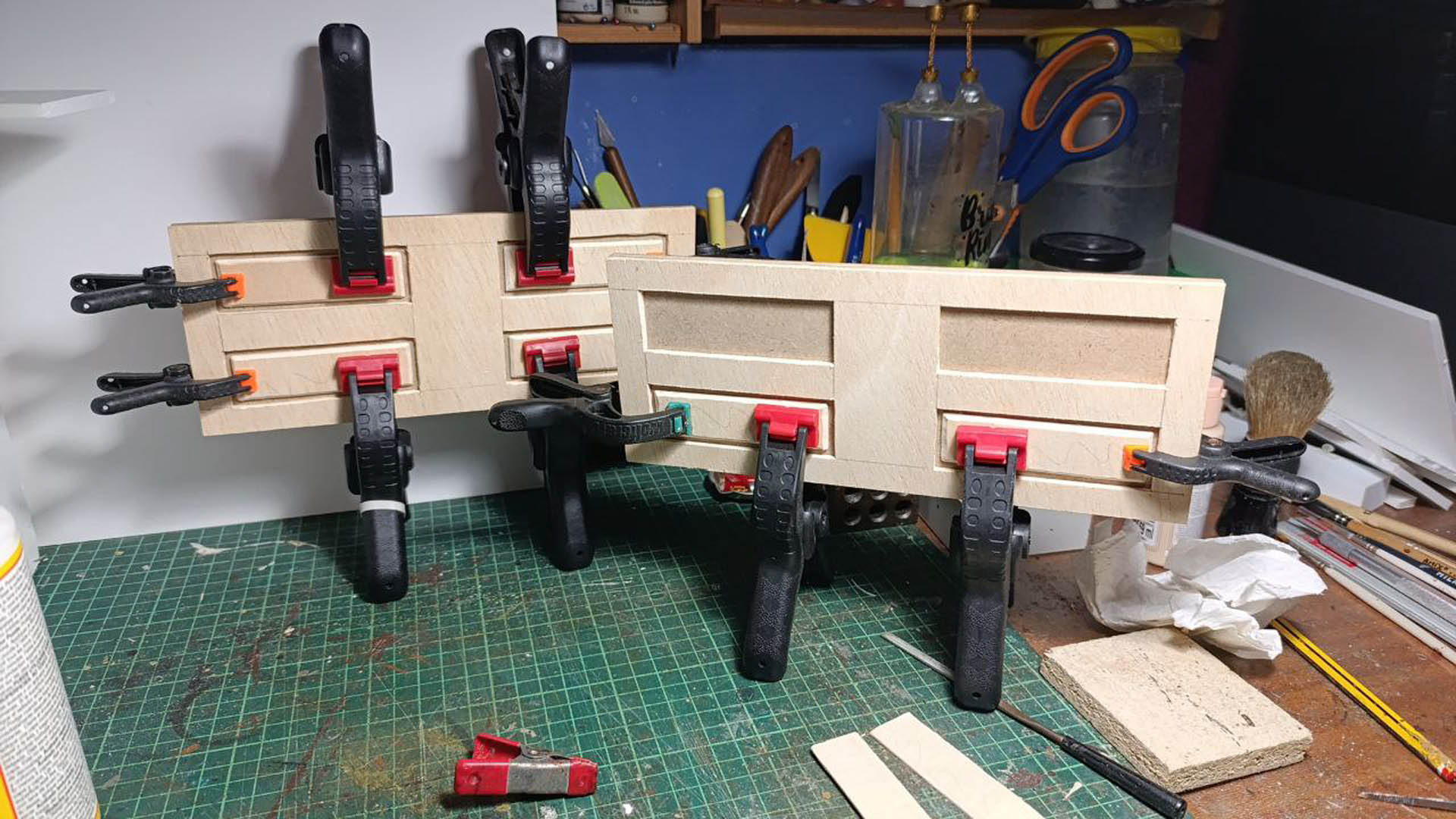 Proceso de construcción del diorama "Las Gemelas": recreación artesanal del pasillo del hotel Overlook con papel pintado geométrico en miniatura, carpintería detallada de puertas de hotel