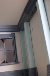 Proceso de construcción del diorama "Las Gemelas": recreación artesanal del pasillo del hotel Overlook con papel pintado geométrico en miniatura, carpintería detallada de puertas de hotel