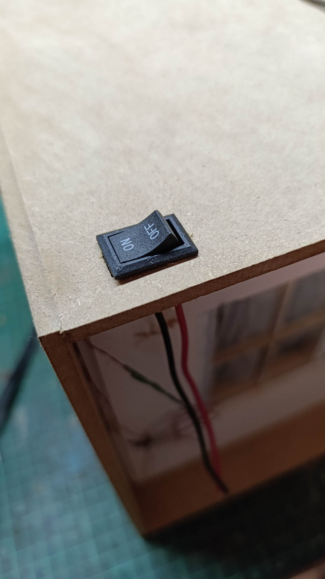 Proceso de construcción del diorama "Las Gemelas": recreación artesanal del pasillo del hotel Overlook con papel pintado geométrico en miniatura, carpintería detallada de puertas de hotel