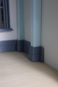 Proceso de construcción del diorama "Las Gemelas": recreación artesanal del pasillo del hotel Overlook con papel pintado geométrico en miniatura, carpintería detallada de puertas de hotel