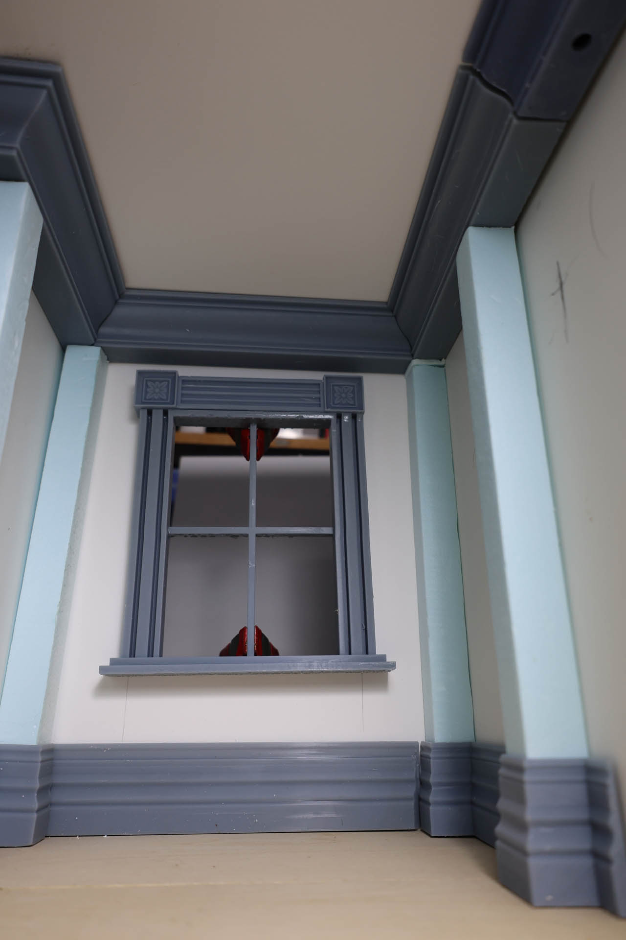 Proceso de construcción del diorama "Las Gemelas": recreación artesanal del pasillo del hotel Overlook con papel pintado geométrico en miniatura, carpintería detallada de puertas de hotel