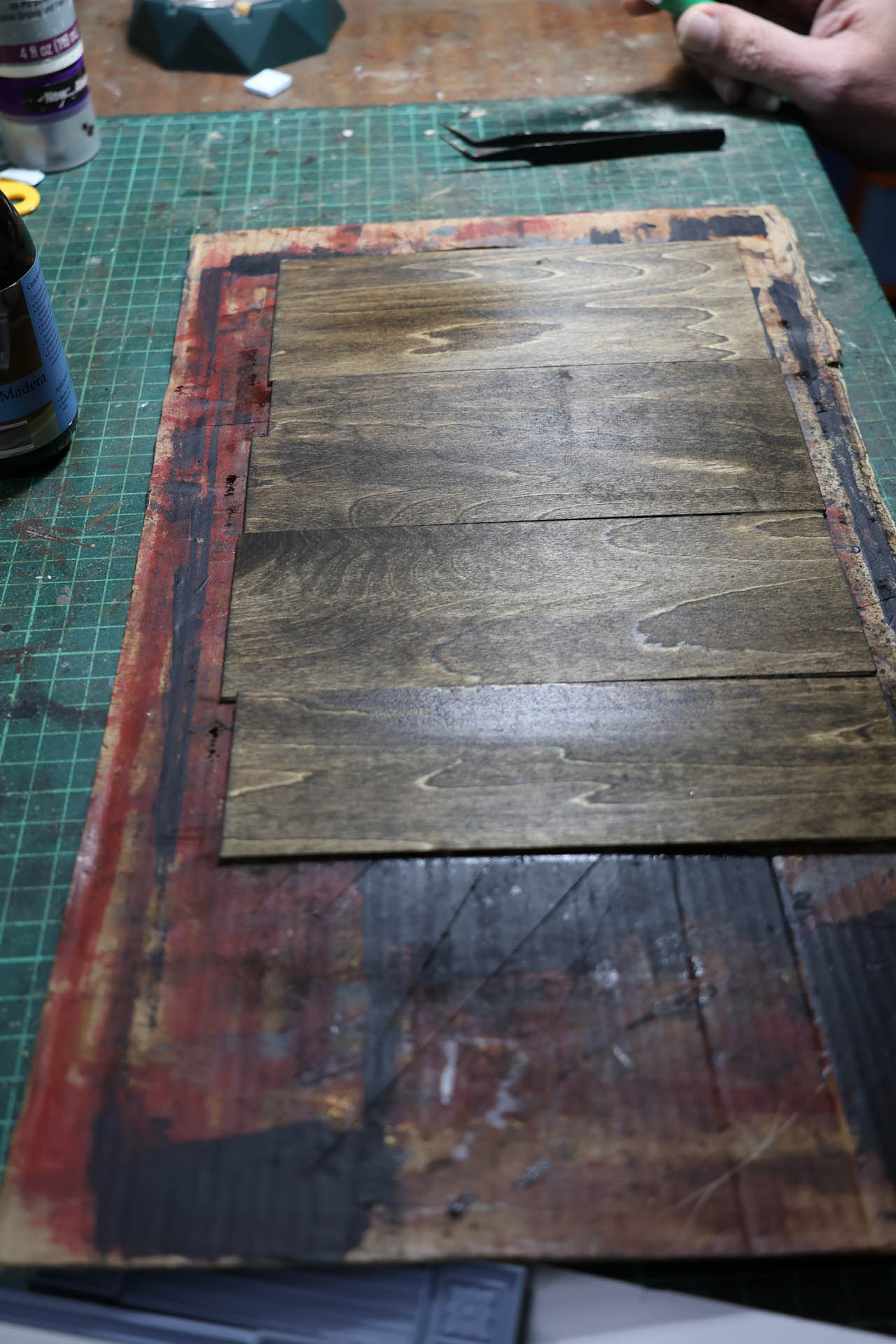 Proceso de construcción del diorama "Las Gemelas": recreación artesanal del pasillo del hotel Overlook con papel pintado geométrico en miniatura, carpintería detallada de puertas de hotel