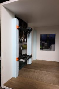 Proceso de construcción del diorama "Las Gemelas": recreación artesanal del pasillo del hotel Overlook con papel pintado geométrico en miniatura, carpintería detallada de puertas de hotel