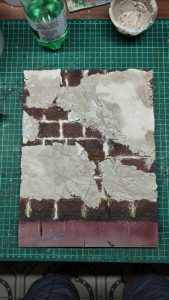 Proceso artesanal del diorama "El Nombre de la Rosa": recreación detallada de los baños del monasterio medieval con Berengario muerto en la bañera, modelado de texturas de piedra húmeda y envejecimiento de mobiliario de madera real