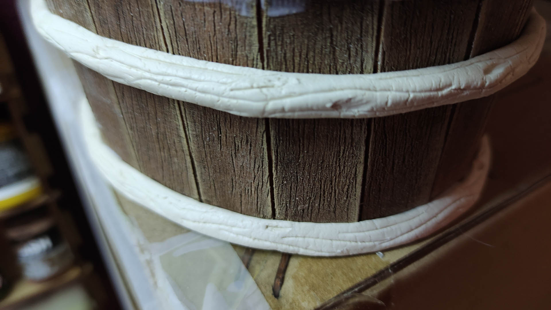 Proceso artesanal del diorama "El Nombre de la Rosa": recreación detallada de los baños del monasterio medieval con Berengario muerto en la bañera, modelado de texturas de piedra húmeda y envejecimiento de mobiliario de madera real