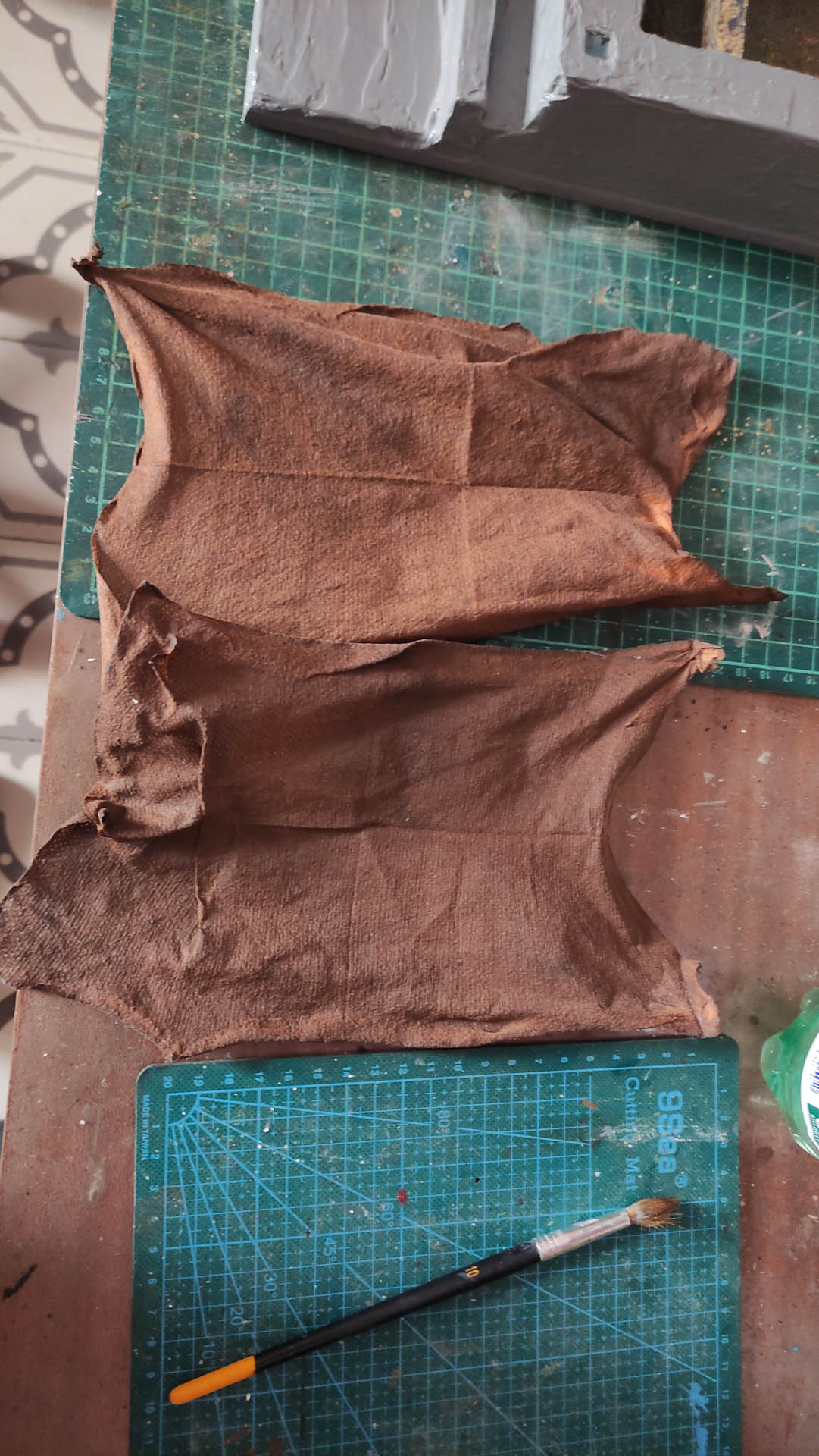 Proceso artesanal del diorama "El Nombre de la Rosa": recreación detallada de los baños del monasterio medieval con Berengario muerto en la bañera, modelado de texturas de piedra húmeda y envejecimiento de mobiliario de madera real