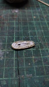 Proceso artesanal del diorama "El Nombre de la Rosa": recreación detallada de los baños del monasterio medieval con Berengario muerto en la bañera, modelado de texturas de piedra húmeda y envejecimiento de mobiliario de madera real