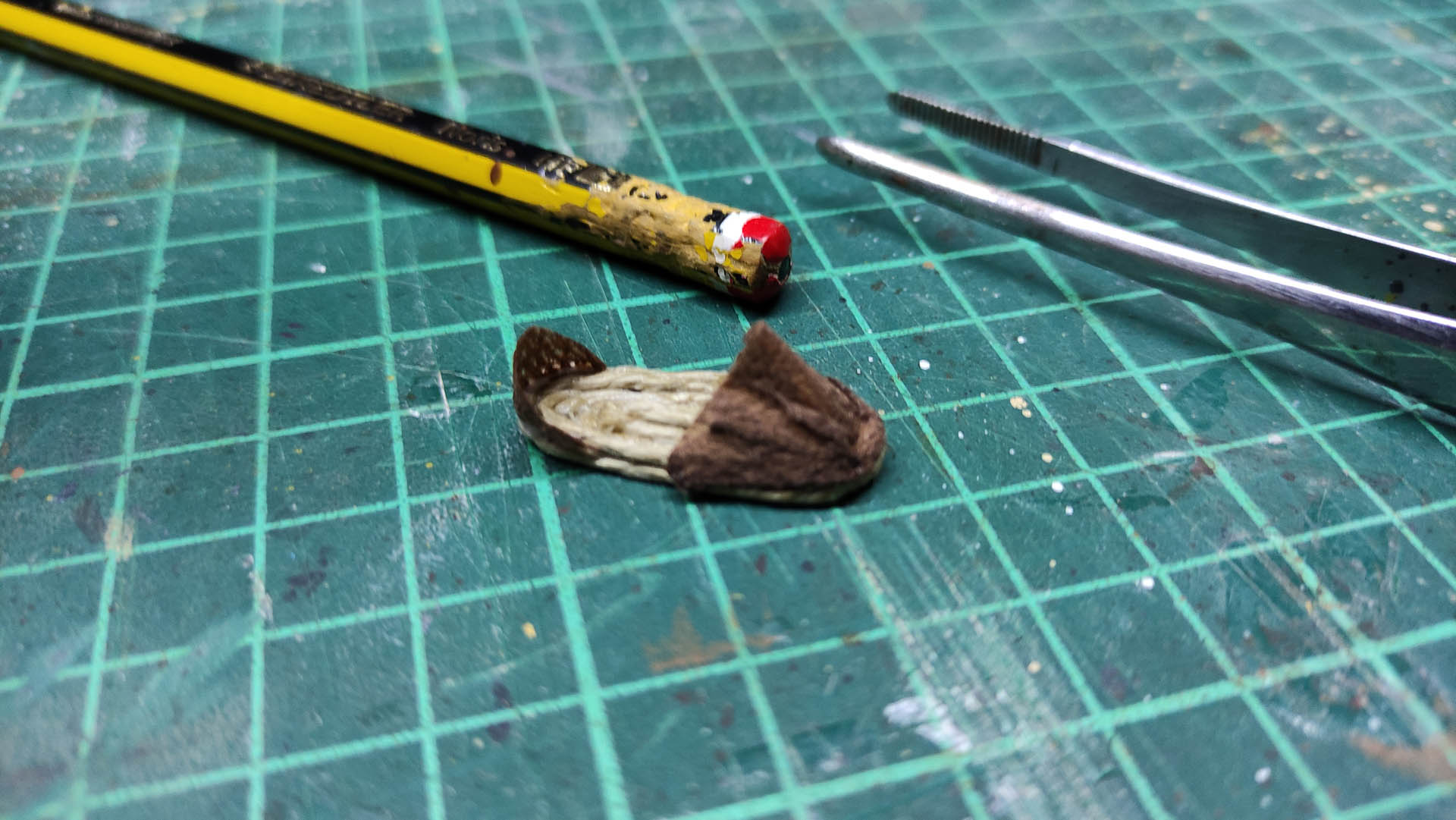 Proceso artesanal del diorama "El Nombre de la Rosa": recreación detallada de los baños del monasterio medieval con Berengario muerto en la bañera, modelado de texturas de piedra húmeda y envejecimiento de mobiliario de madera real