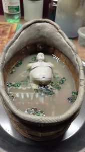 Proceso artesanal del diorama "El Nombre de la Rosa": recreación detallada de los baños del monasterio medieval con Berengario muerto en la bañera, modelado de texturas de piedra húmeda y envejecimiento de mobiliario de madera real