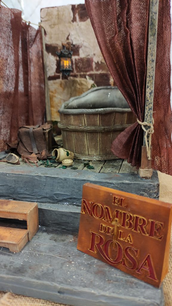 Miniatura artesanal inspirada en El Nombre de la Rosa. Diorama detallado de un baño medieval con efectos de agua realistas, muebles de madera hechos a mano y arquitectura gótica en miniatura por 27dioramas.