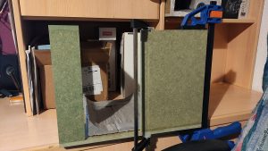 Diorama artesanal de Venecia durante la peste negra, mostrando a dos médicos de la peste con máscara frente a una góndola en un canal, con iluminación de farol.