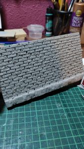 Diorama artesanal de Venecia durante la peste negra, mostrando a dos médicos de la peste con máscara frente a una góndola en un canal, con iluminación de farol.