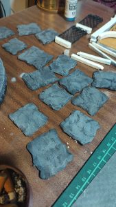 Diorama artesanal de Venecia durante la peste negra, mostrando a dos médicos de la peste con máscara frente a una góndola en un canal, con iluminación de farol.