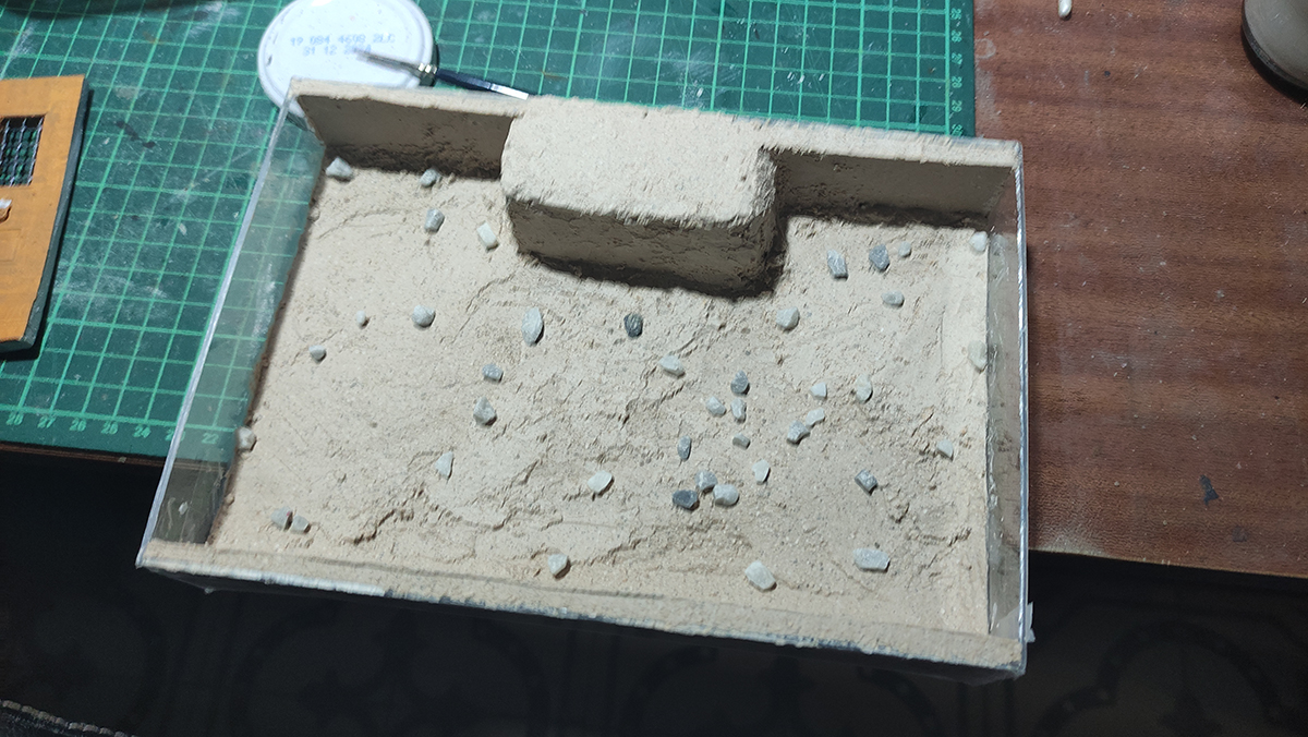 Diorama artesanal de Venecia durante la peste negra, mostrando a dos médicos de la peste con máscara frente a una góndola en un canal, con iluminación de farol.