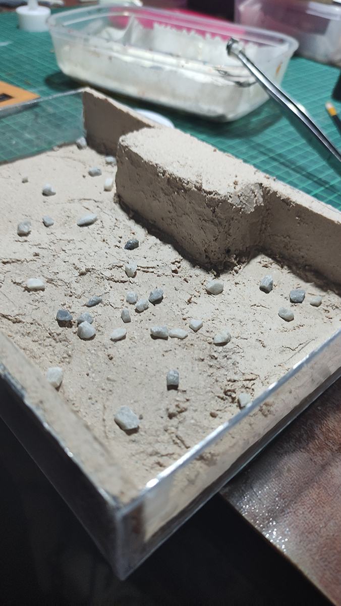 Diorama artesanal de Venecia durante la peste negra, mostrando a dos médicos de la peste con máscara frente a una góndola en un canal, con iluminación de farol.