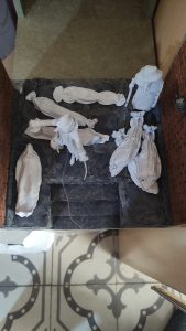 Diorama artesanal de Venecia durante la peste negra, mostrando a dos médicos de la peste con máscara frente a una góndola en un canal, con iluminación de farol.