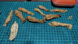 Diorama artesanal de Venecia durante la peste negra, mostrando a dos médicos de la peste con máscara frente a una góndola en un canal, con iluminación de farol.