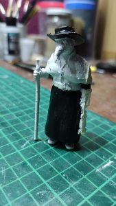 Diorama artesanal de Venecia durante la peste negra, mostrando a dos médicos de la peste con máscara frente a una góndola en un canal, con iluminación de farol.