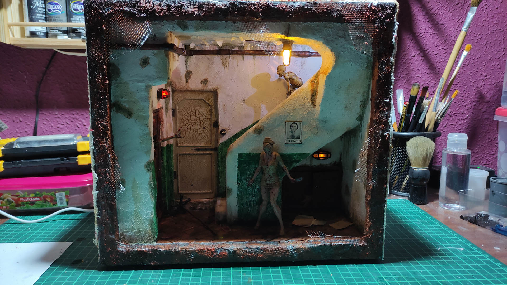 Proceso de creación de diorama artesanal inspirado en Silent Hill: detalles de construcción, pintura técnica y envejecido de escenarios de terror en miniatura.