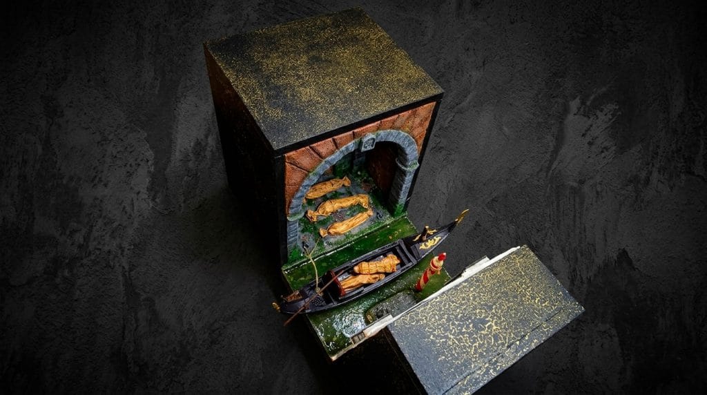 Vista superior del diorama de Venecia con góndola y cuerpos envueltos en mortajas, mostrando el acabado exterior artístico y la estructura del book nook.