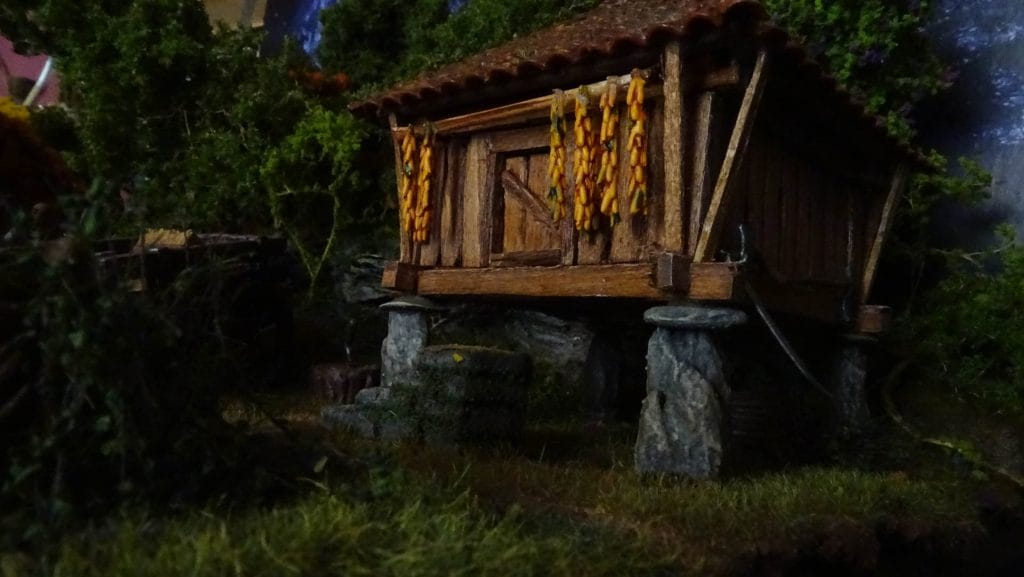 Diorama de hórreo gallego artesanal con techo removible e interior detallado con sacos de grano