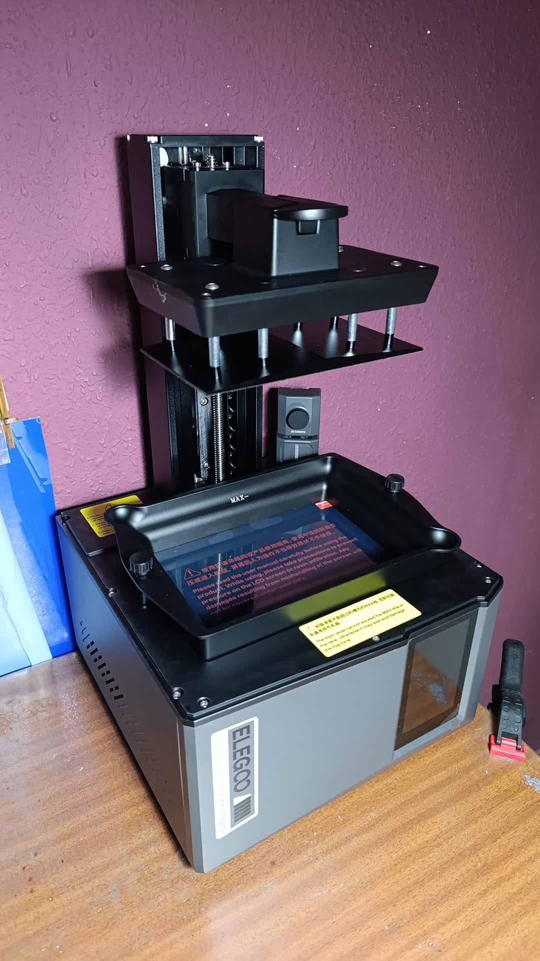 Detalle del equipo de impresión 3D de resina utilizado en el proceso de scratch building para fabricar accesorios y personajes detallados a escala.