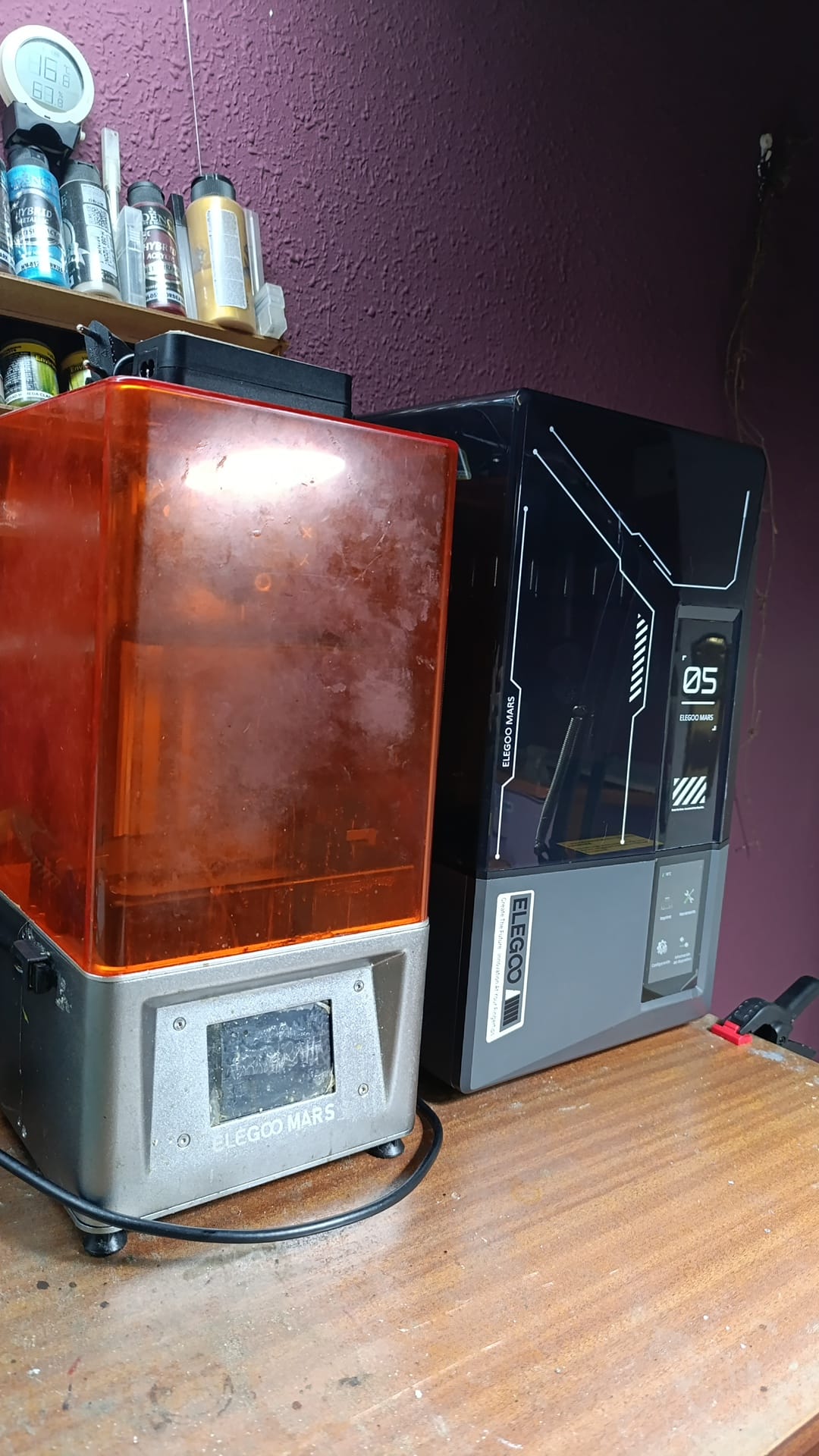 Detalle del equipo de impresión 3D de resina utilizado en el proceso de scratch building para fabricar accesorios y personajes detallados a escala.