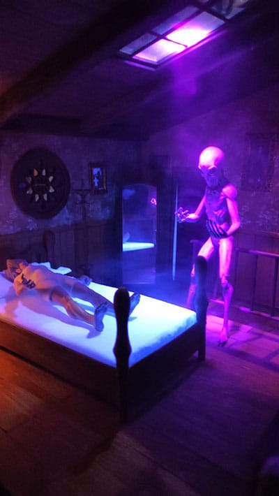 Diorama de casa victoriana de terror. Escena de parálisis del sueño en miniatura con visitante de dormitorio acechando