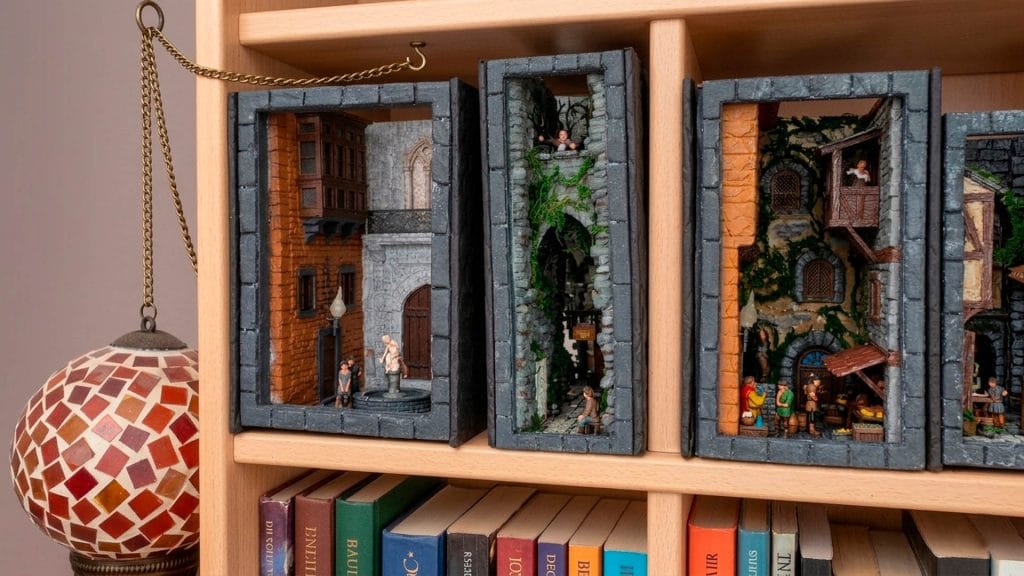 Colección de book nooks artesanales en estantería con escenas de ciudades medievales y callejones antiguos