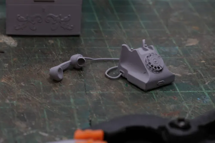 Teléfono en miniatura impreso e imprimado, antes de pintarlo